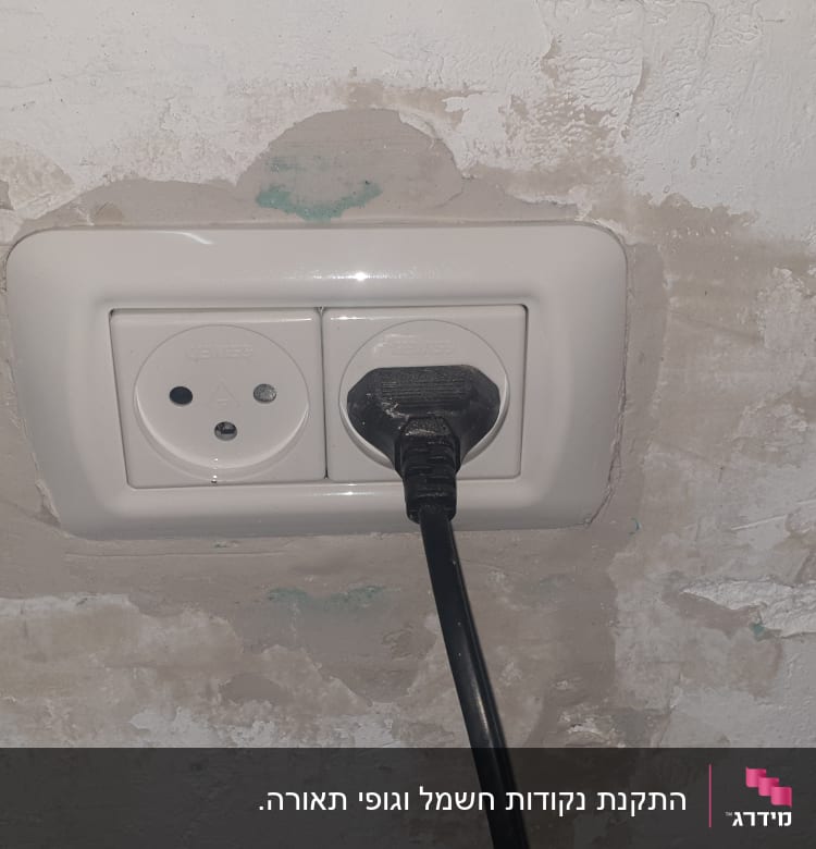 שקע חשמל עם תקע מחובר בקיר